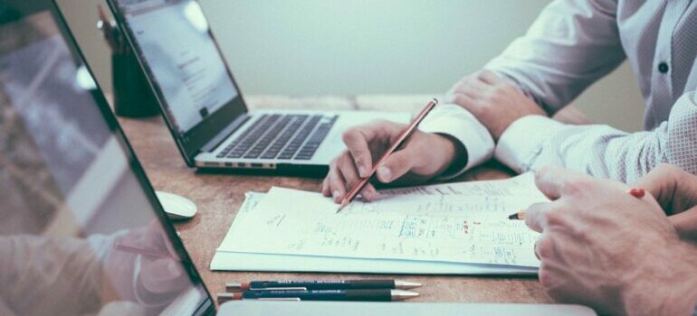 Two people making a plan in front of laptops.