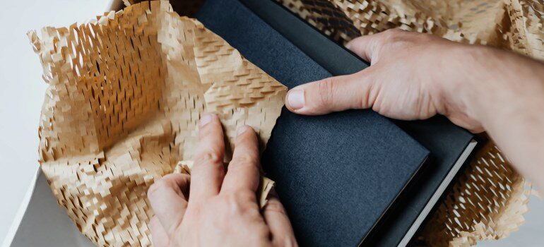 person carefully packing books for the move
