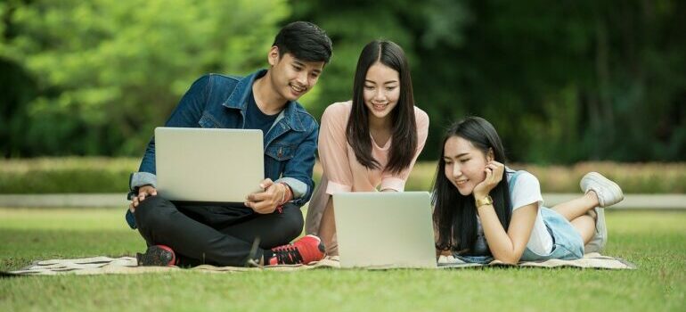 Three students looking at their laptops.
