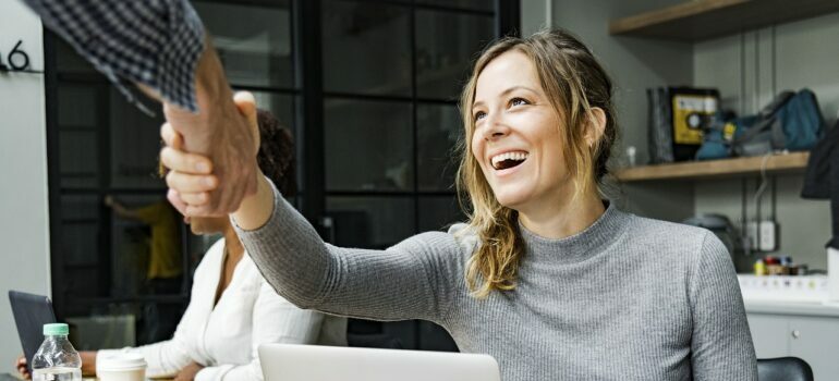 A woman shaking hands with hourly movers Austin.