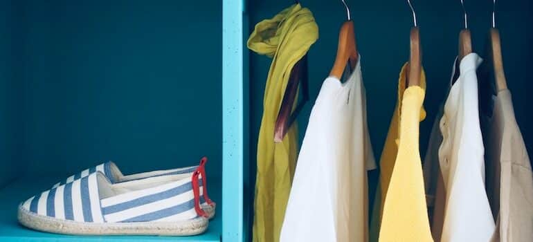 closet with shoes and few shirts on a hanger