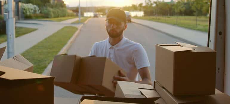 A man unloading the moving vehicle