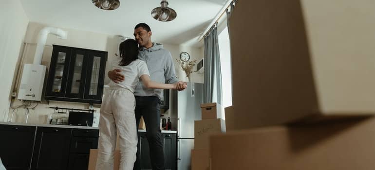 A couple dancing next to moving boxes