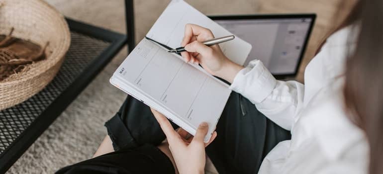 Person writing in a planner to organize a long-distance move from South Austin