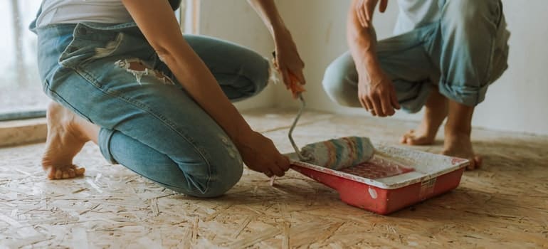 A couple following decorating tips and painting the walls
