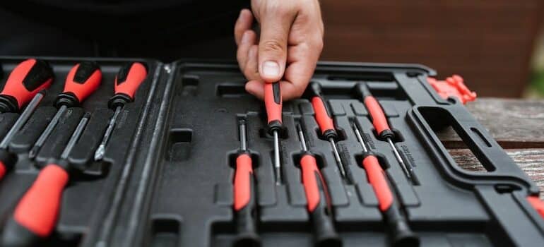 Hand taking a tool from a tool box