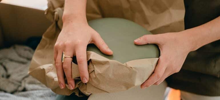 hands wrapping with paper a bowl