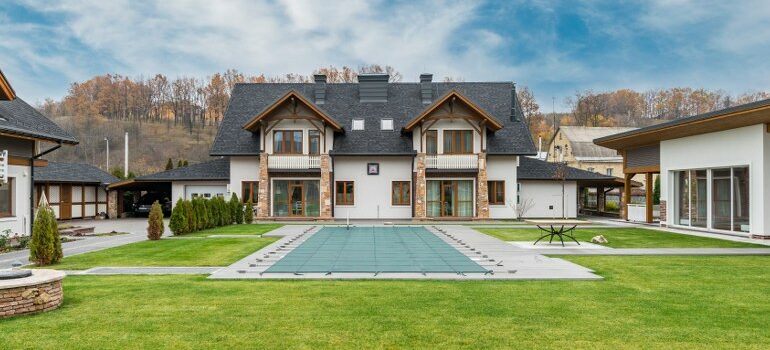big, residential house with a pool in front