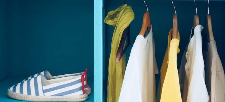 shoes and shirts hanging in a closet