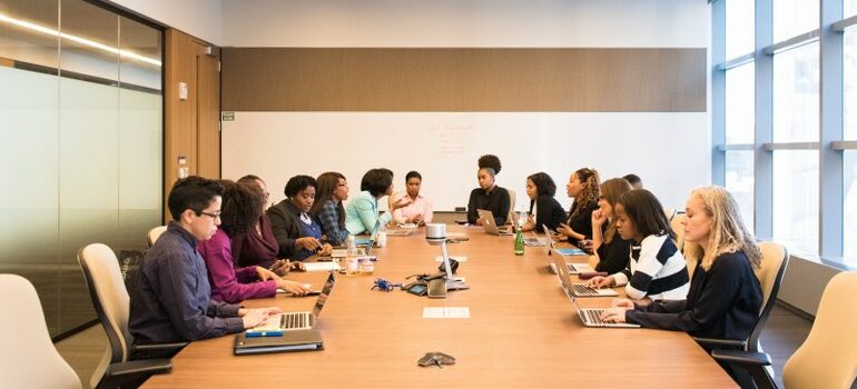 business meeting, plenty of people sitting at the table in the office