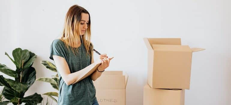 a woman writing on paper how to organize your Austin storage unit
