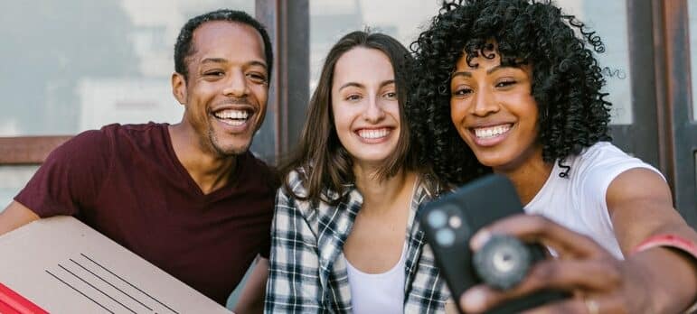 a group of friends making a selfie while holding boxes