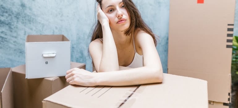 gilr sitting with moving boxes ready for storage