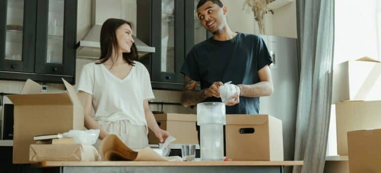 a couple using cardboard boxes for additional storage