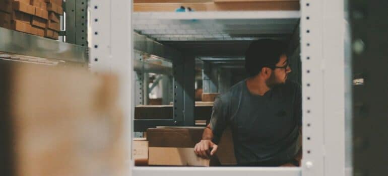 a man in-between shelves inside a storage unit