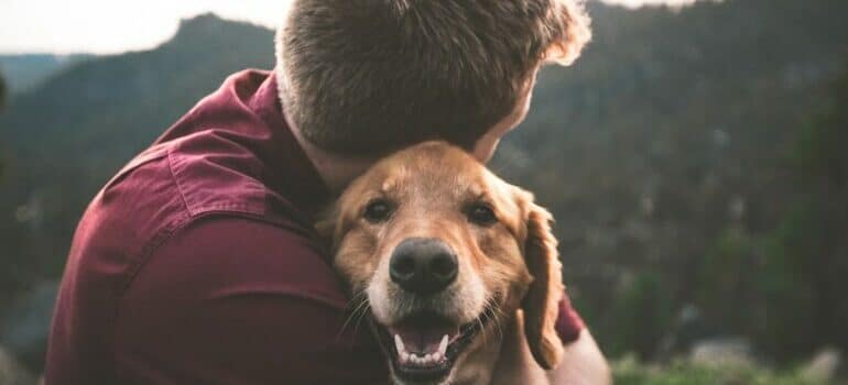 hugging a dog in order to help your pet adjust to a new home