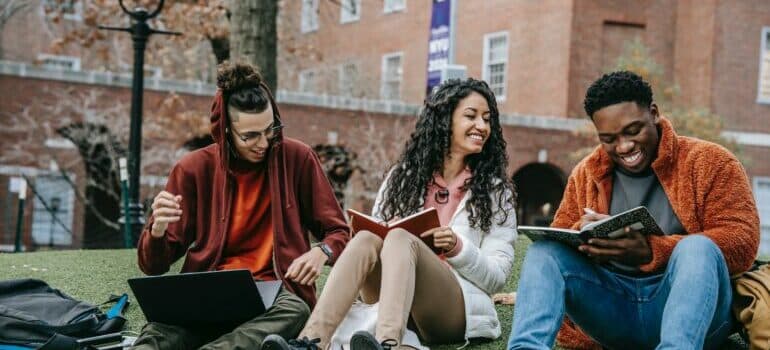 Three friends sitting on the grass