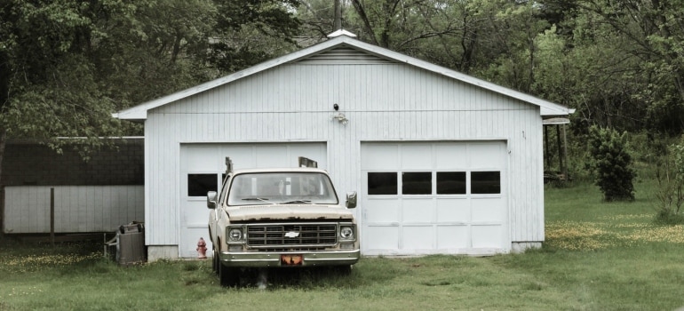 a white car in front of a two door garage