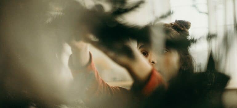 Woman undecorating a Christmas tree