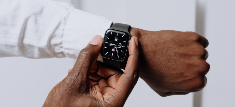 The man is holding a wristwatch.