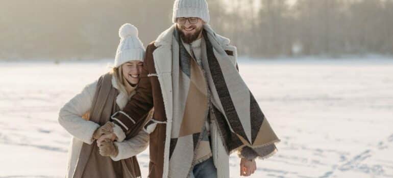 a happy couple ice skating on an open, frozen lake