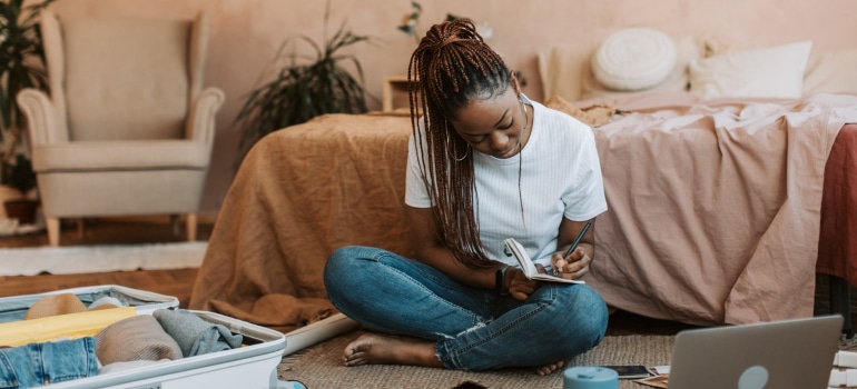 a woman writing a checklist making sure she can organize commonly forgotten items