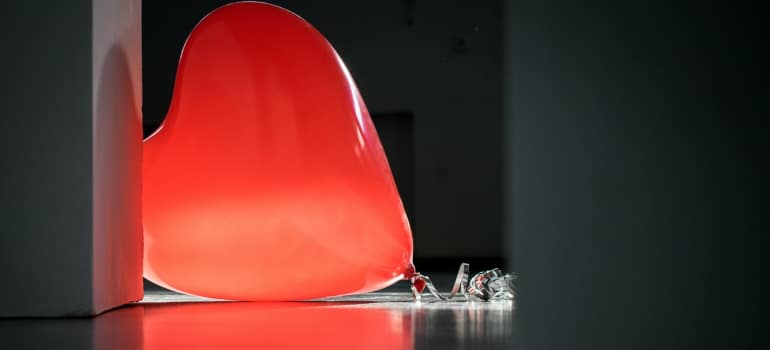 a single red heart-shaped balloon on the floor to represent one of many Valentine's Day decorating ideas