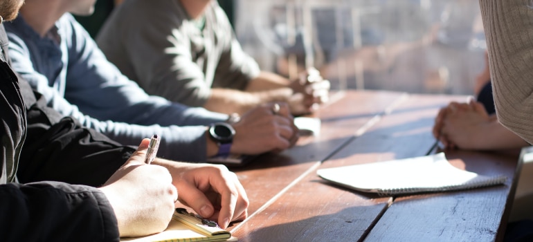 a team of employees in an office, writing down everything they might need for the relocation