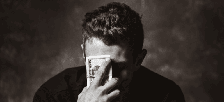 a man holding money and thinking about types of moving insurance