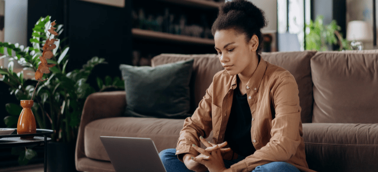 a woman sitting and getting an accurate moving estimate on a laptop