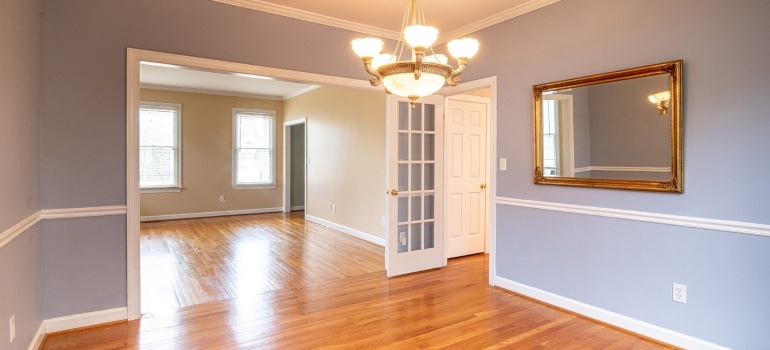 An empty room with wooden floors and white walls.
