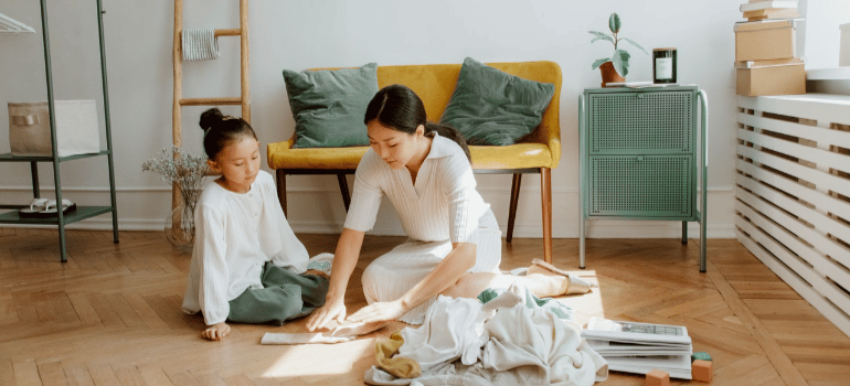 a woman preparing something on a floor with a child