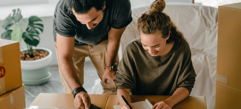 a man and a woman writing something on a piece of paper