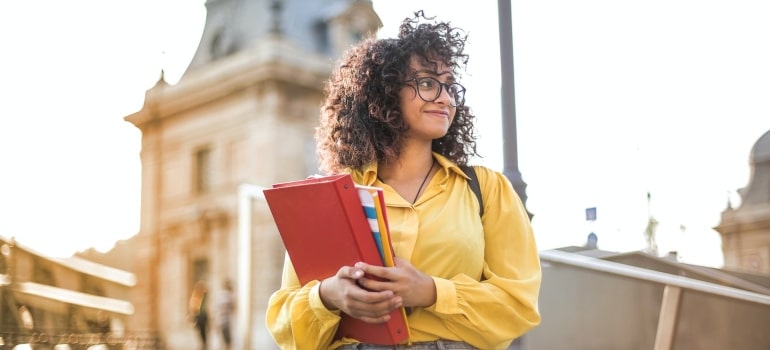 A female student in yellow shirt knows moving day tips and tricks for students.
