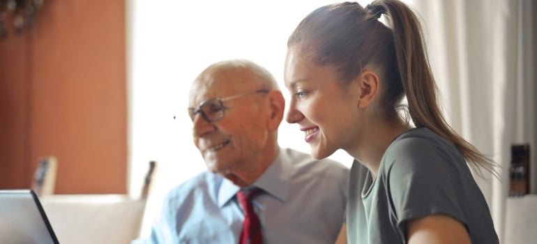grandpa and grandma reading about stress-free moving for seniors on their laptop 