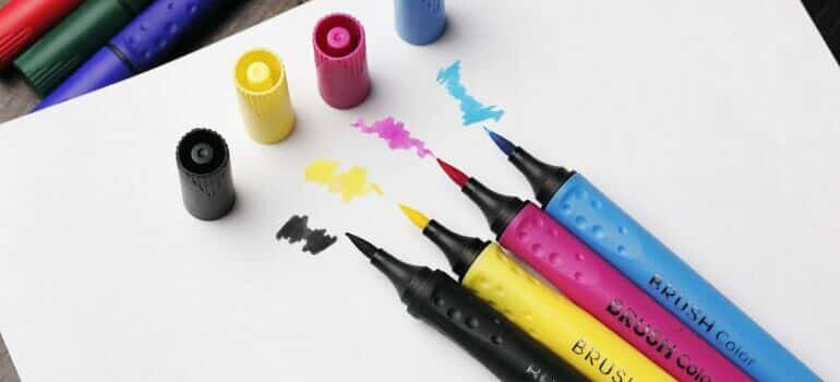 brush coloring pens on top of white paper