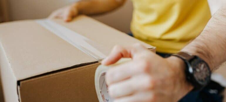 man taping a box