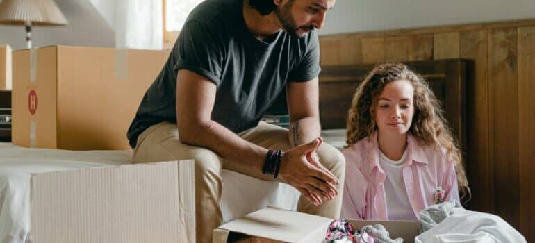 Couple sitting in front of half packed moving boxes