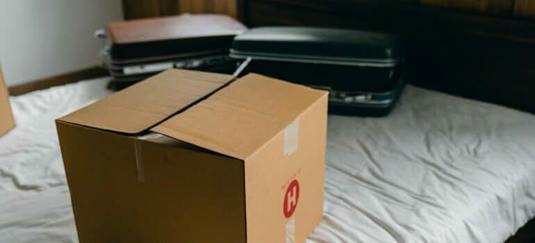 cardboard boxes and suitcases on a bed