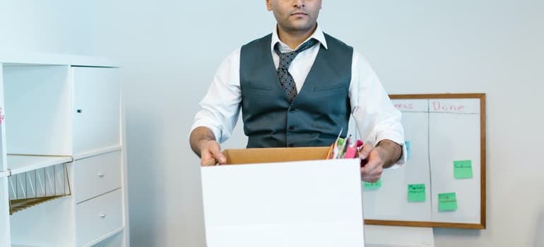 Man unpacking a box in his new office;