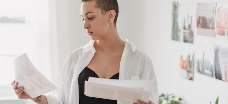 Designer choosing photo on a paper sheet in-house. 