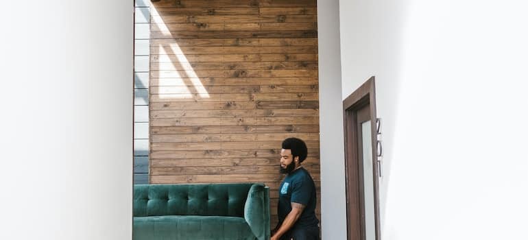 A professional mover carrying a sofa;