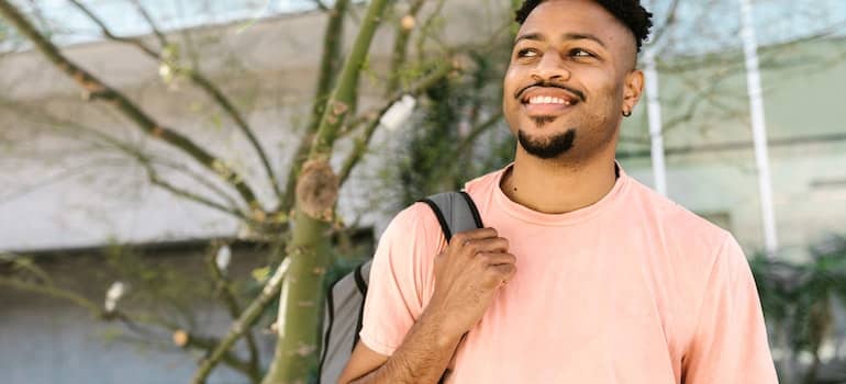 A man with his backpack moving into a college dorm