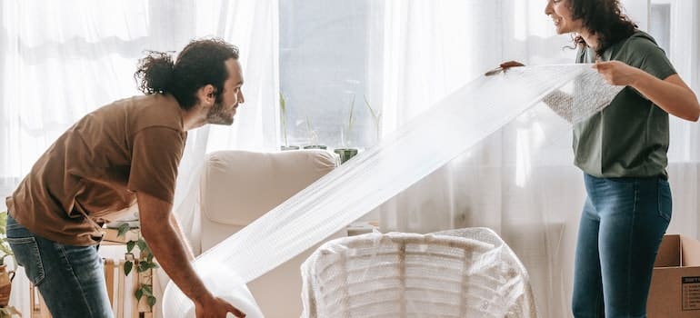 A couple wrapping a chair to avoid cluttering a small Austin home