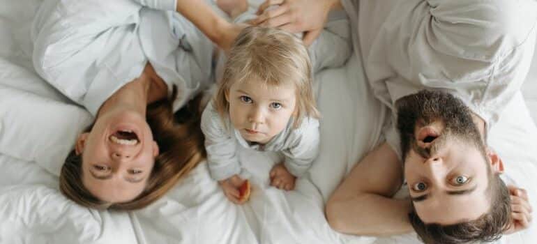 parents with a kid on the bed