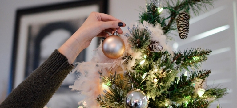 A person decorating their Christmas tree
