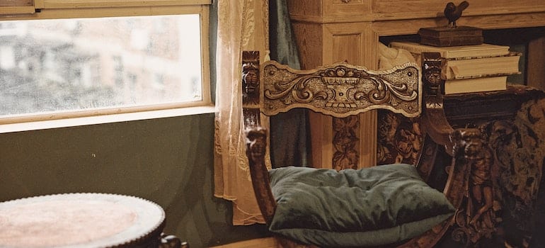 Brown wooden armchair next to a window