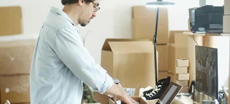 man packing shoes for moving to Austin TX on a budget