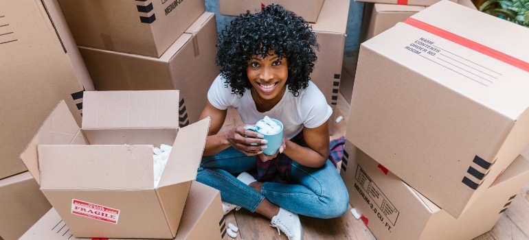 A woman sitting among moving boxes