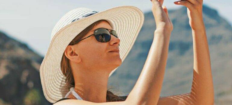Woman with sunglasses and hat in the sun